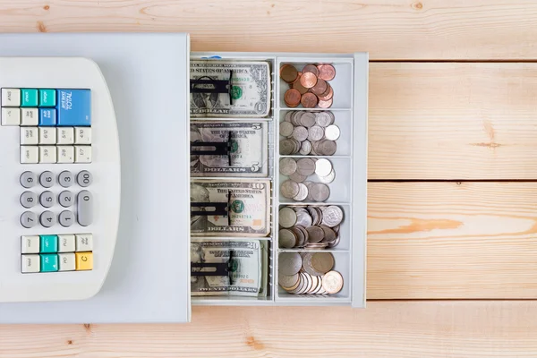 Cash register full of coins and paper money