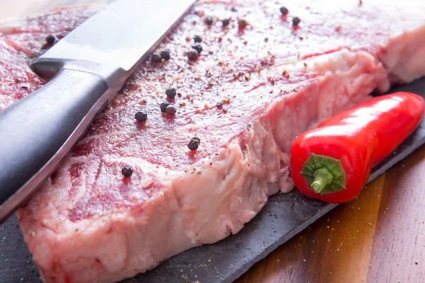 Marinated Steak with Pepper and Knife on a Table
