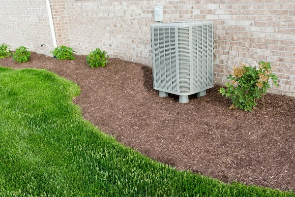 Air conditioner condenser unit standing outdoors