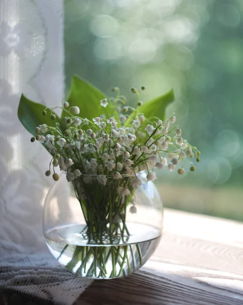 Bouquet of lilies of the valley in a round vase