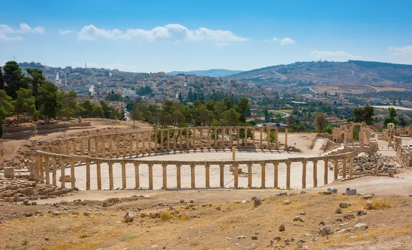 Ruins of the Forum Cardo at Jerash Jordan with modern city view