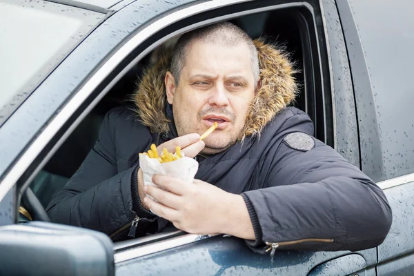 Man eating french fries in the car