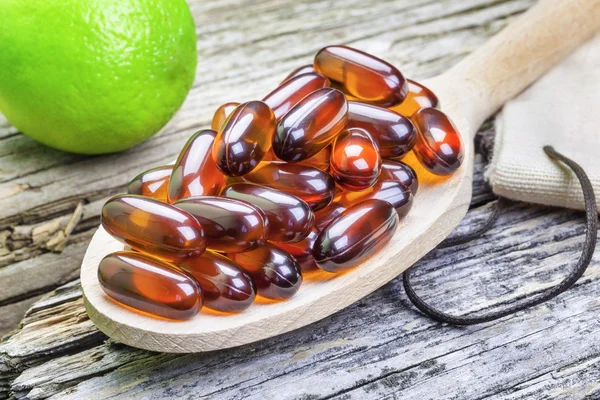 Extra strong fish oil capsules with lime in background