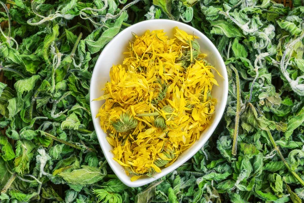 Dry calendula with green dry herbs around