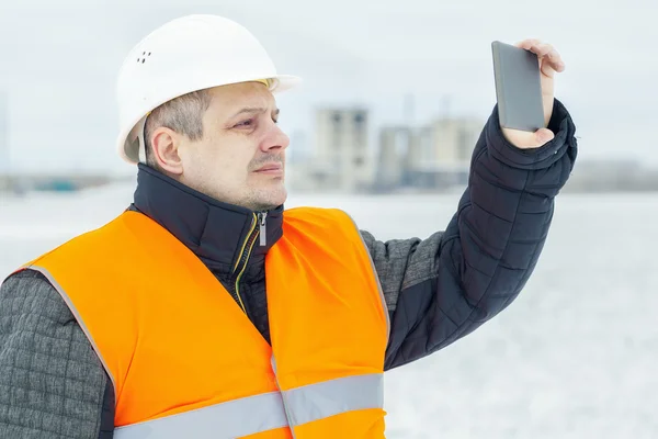 Engineer with tablet PC on the field in winter