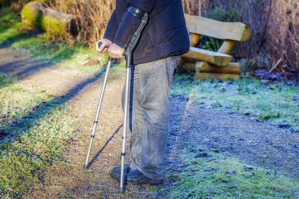 Disabled man on crutches at outdoor on the path