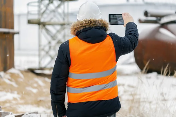 Engineer filmed with tablet PC in the factory in winter