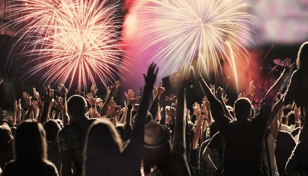 New Year concept - cheering crowd and fireworks