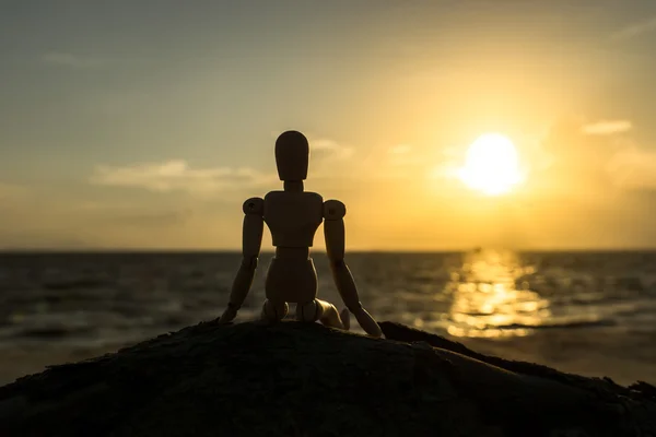 Silhouettes of wooden models feel lonely at sunset.