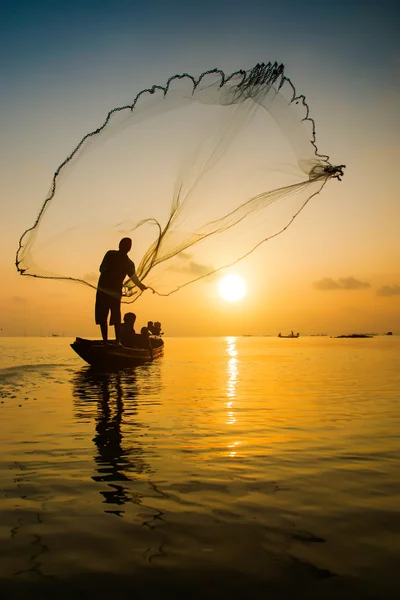 Silhouettes fisherman throwing fishing nets during sunset, Thail