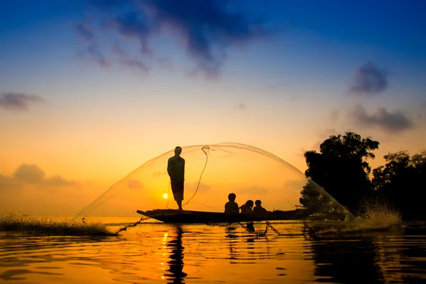 Silhouettes fisherman throwing fishing nets during sunset, Thail