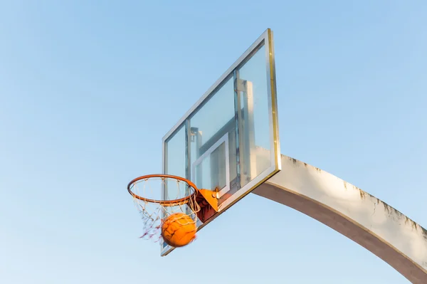 Basketball going through basketball hoop and net