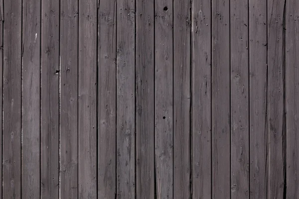 Fence of vertical old brown purple planks or side of shed