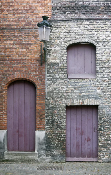 Closed purple doors and shutters in the old town of bruges in be