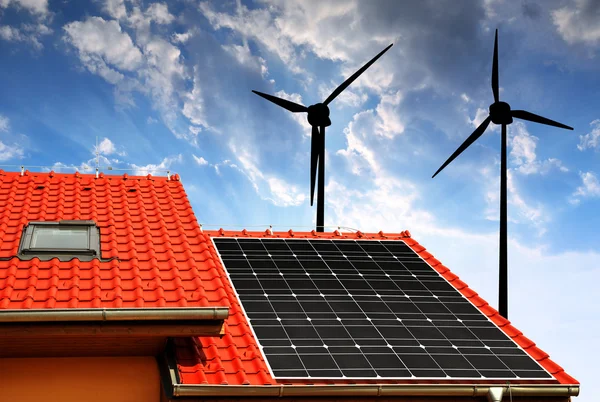 Solar panel on the roof of the house and wind turbines