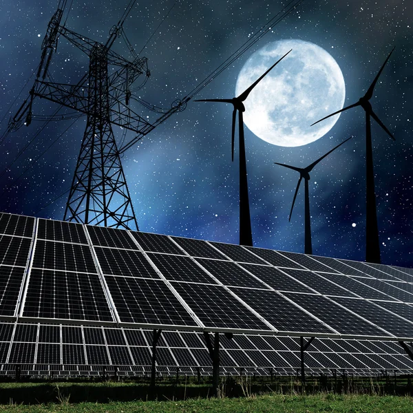 Solar panels with wind turbines and electricity pylon in night.