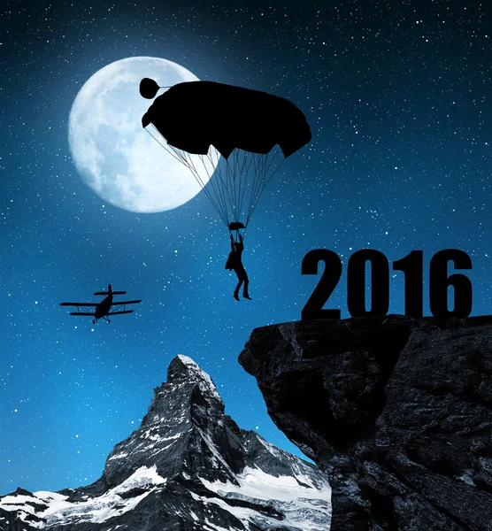 Silhouette skydiver parachutist landing in to the New Year 2016