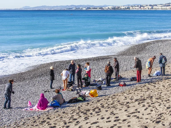 NICE, FRANCE - on JANUARY 13, 2016. People have a rest on the city beach in the winter sunny day