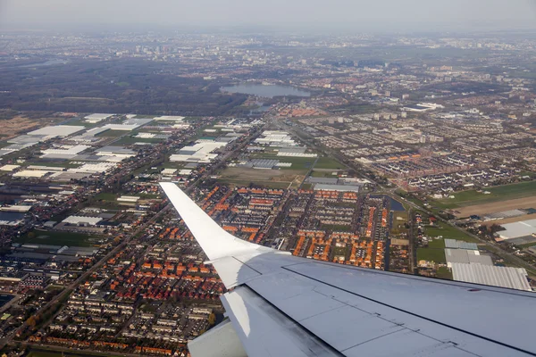 View from the window of the flying plane on clouds and a terrestrial surface below