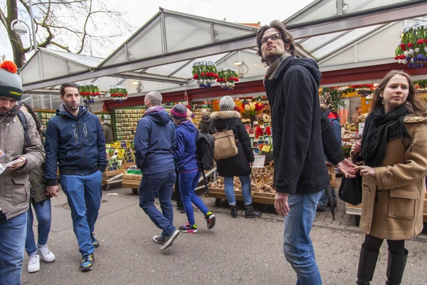 AMSTERDAM, NETHERLANDS on MARCH 27, 2016. Tourists walk in the Flower market. The flower market is one of sights of the city