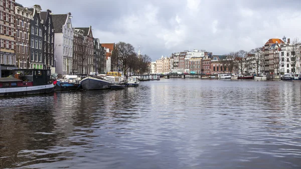 AMSTERDAM, NETHERLANDS on MARCH 28, 2016. River Amstel. Architectural complex of the embankment. Boats are moored at the coast.