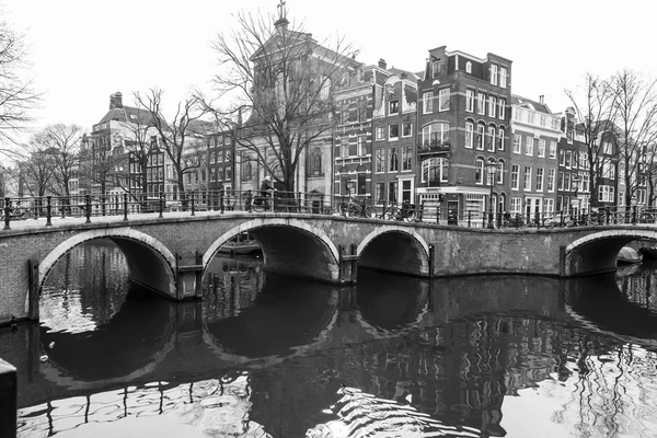 AMSTERDAM, NETHERLANDS on MARCH 31, 2016. Typical urban view. Obridge via the channel. The channel and buildings of the XVII-XVIII construction on embankments.