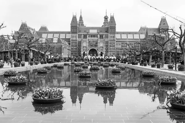 AMSTERDAM, NETHERLANDS on MARCH 31, 2016. Museum Square. Rijksmuseum. Tourists have a good time near the inscription I AMsterdam. The fountain decorated by flowerpots with tulips
