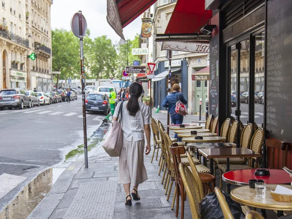 PARIS, FRANCE, on JULY 12, 2016. Little tables of typical Parisian cafe on the sidewalk near big window.
