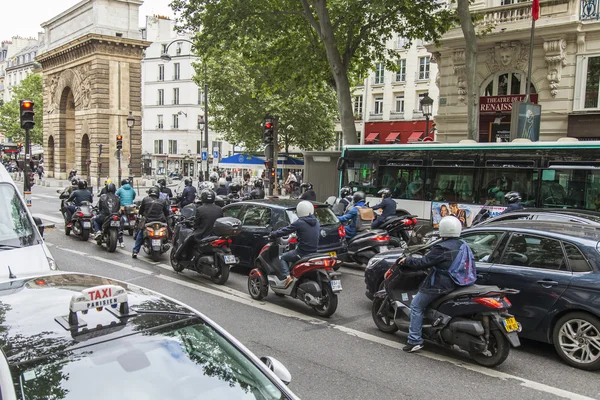 PARIS, FRANCE, on JULY 12, 2016. Typical urban view. A steam of cars and motorcyclists goes down the street.