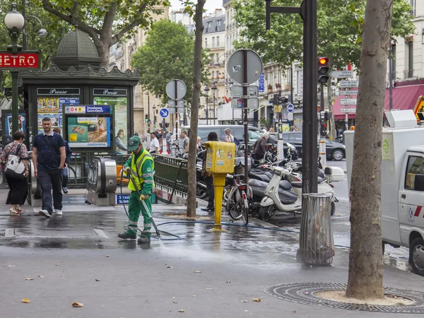 PARIS, FRANCE, on JULY 12, 2016. The janitor washes the sidewalk of the city street