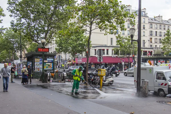 PARIS, FRANCE, on JULY 12, 2016. The janitor washes the sidewalk of the city street