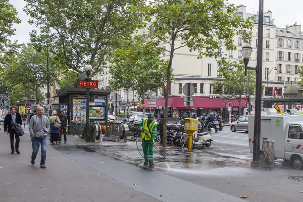 PARIS, FRANCE, on JULY 12, 2016. The janitor washes the sidewalk of the city street