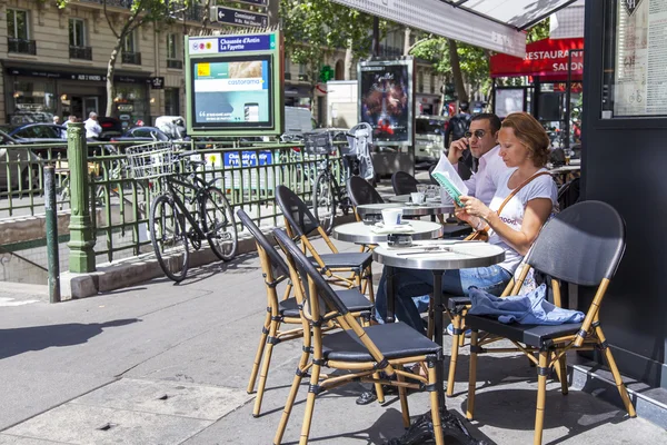 PARIS, FRANCE, on JULY 12, 2016. Typical city street. People rest in summer cafe on the sidewalk.