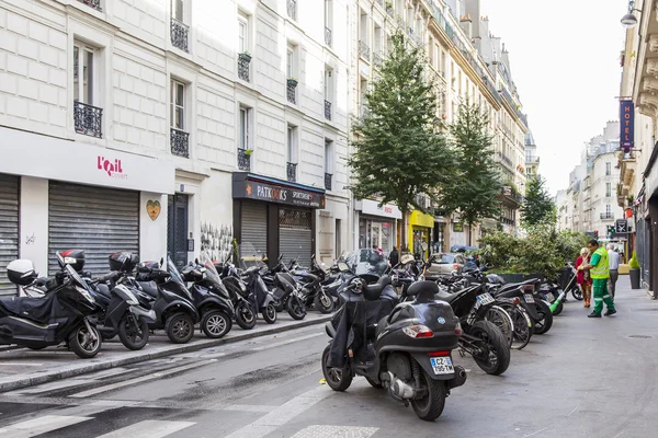 PARIS, FRANCE, on JULY 5, 2016. Typical Parisian street in the morning. Motorcycles are parked near the sidewalk