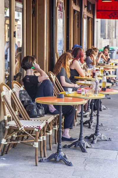 PARIS, FRANCE, on JULY 5, 2016. Typical Parisian street in the morning. People have a rest and eat in cafe under the open sky.