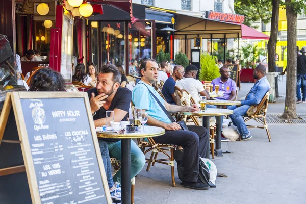 PARIS, FRANCE, on JULY 7, 2016. Typical Parisian street in the morning. People eat and have a rest in cafe under the open sky.