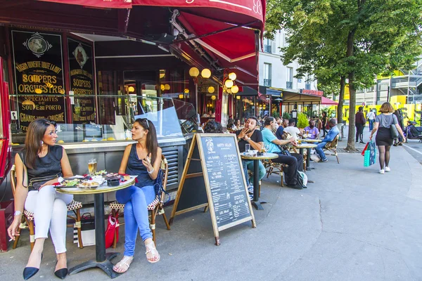 PARIS, FRANCE, on JULY 7, 2016. Typical Parisian street in the morning. People eat and have a rest in cafe under the open sky.