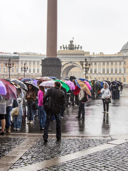 St. Petersburg, Russia, on July 24, 2012. Tourists and citizens stand in the rain in a queue to get to the museum the State Hermitage. The Hermitage - one of the best-known art museums of the world