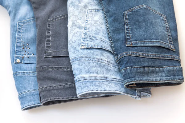 Jeans of various colors on a counter in shop
