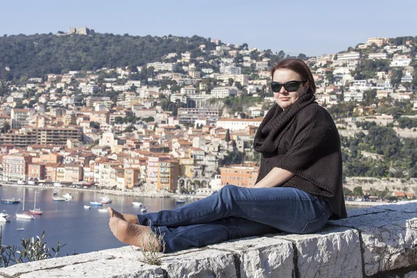 Vilfransh, France, on March 10, 2015. The happy woman is photographed against a beautiful landscape, the old city and the sea