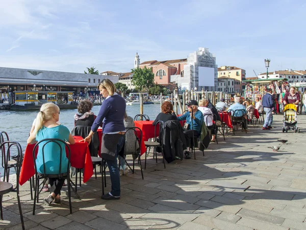 VENICE, ITALY - on APRIL 29, 2015. People have a rest and eat in summer cafe on the bank of the Grand channel (Canal Grande).