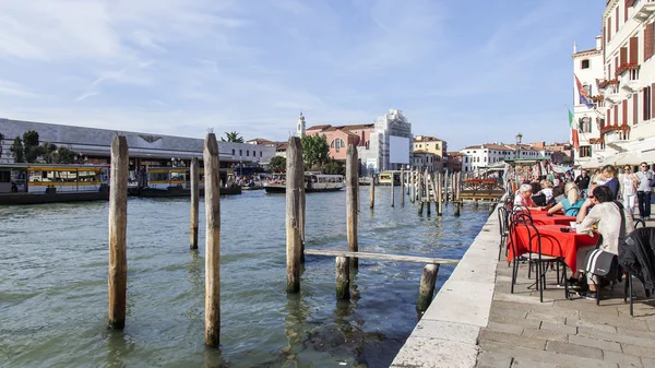 VENICE, ITALY - on APRIL 29, 2015. People have a rest and eat in summer cafe on the bank of the Grand channel (Canal Grande).