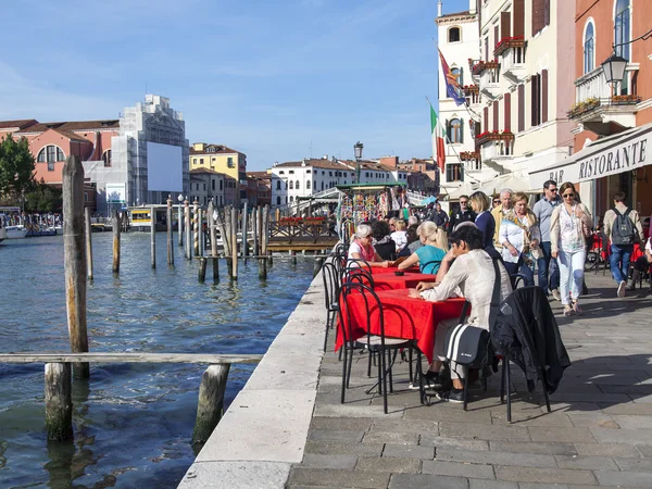 VENICE, ITALY - on APRIL 29, 2015. People have a rest and eat in summer cafe on the bank of the Grand channel (Canal Grande).