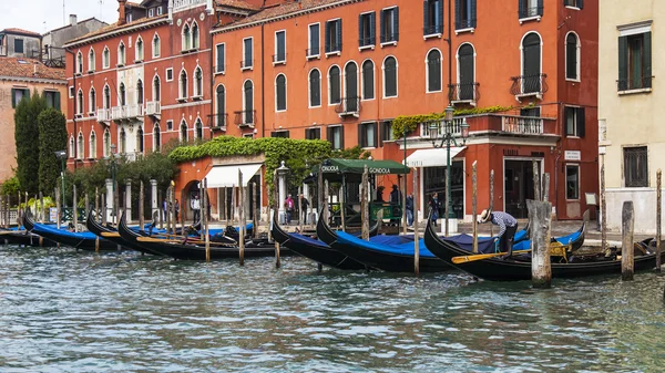 VENICE, ITALY - on APRIL 30, 2015. An architectural complex of ancient buildings on the bank of the Grand channel (Canal Grande). Gondolas at pier. The grand channel is the main transport artery of Venice and its most known channel