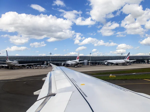 PARIS, FRANCE - on MAY 5, 2015. The international airport Charles de Gaulle, a view of the terminal E and the planes having preflight training from a window of the flying-up plane