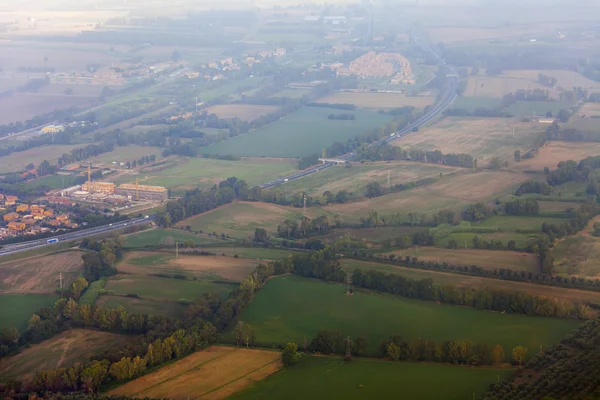 View from the window of the flying plane on clouds and a terrestrial surface below