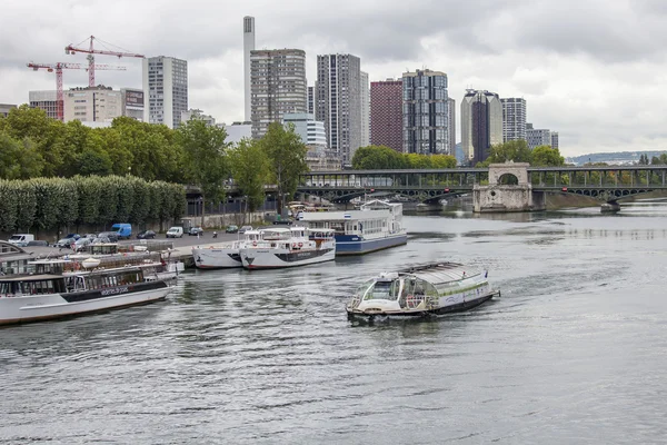 PARIS, FRANCE, on SEPTEMBER 1, 2015. A view of Seine and the walking ships moored to the embankment. Pont de Bir Hakeim in Paris. Famous bridge over the river Seine.