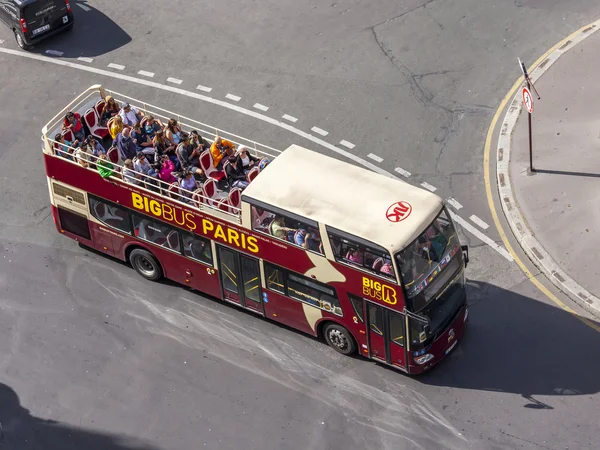 PARIS, FRANCE, on AUGUST 26, 2015. The excursion bus with passengers goes on the city street. The top view from a survey platform.