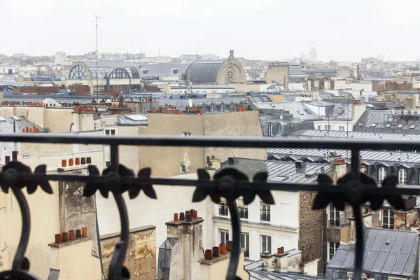 PARIS, FRANCE, on AUGUST 27, 2015. A view from a balcony with a beautiful protection on the city in rainy weather. Roofs of Paris wet from a rain