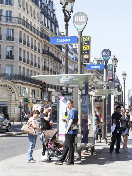 PARIS, FRANCE, on AUGUST 26, 2015. Typical city street in the summer solar morning. People stand on the bus-stop